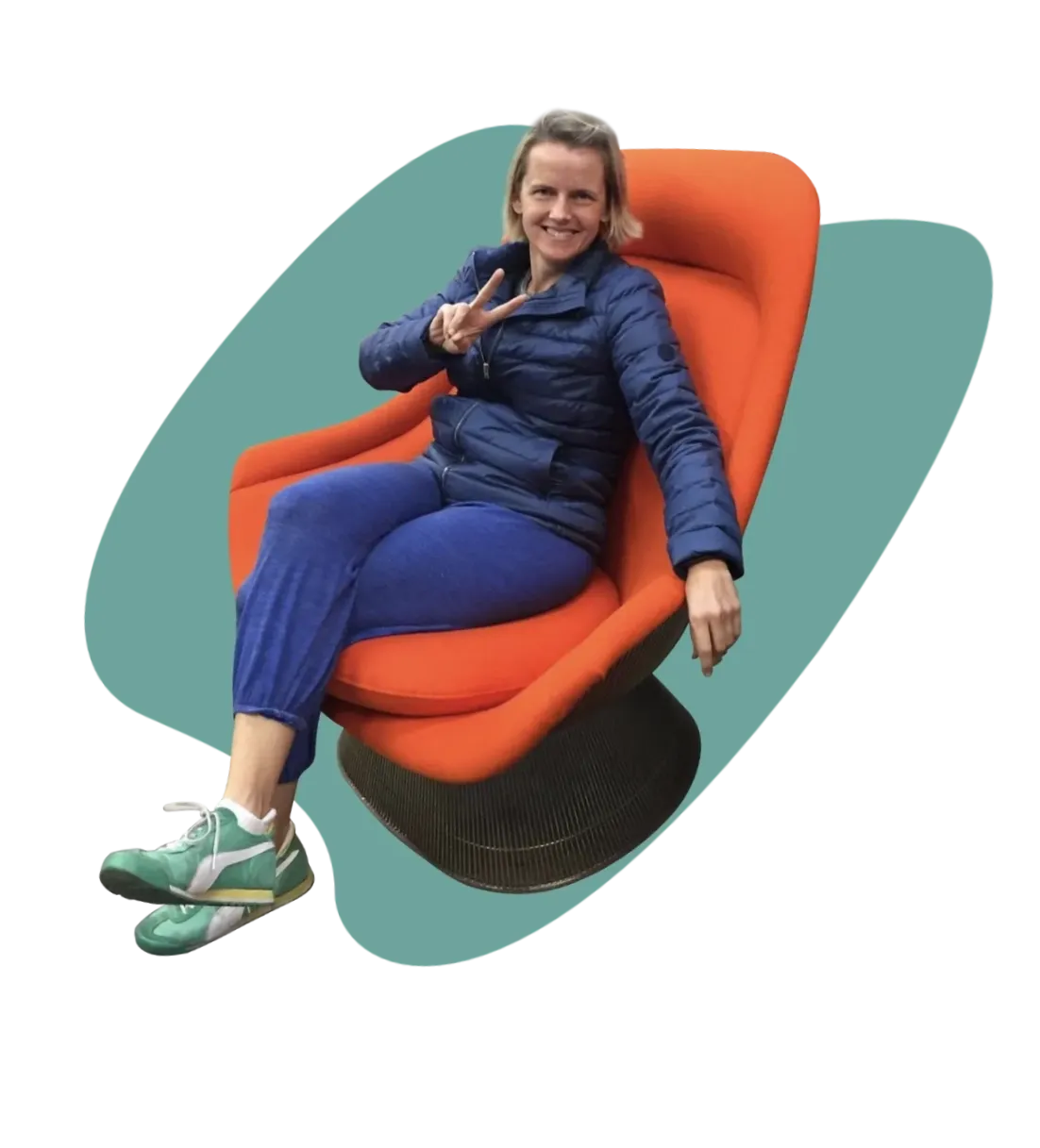 Happy woman giving the peace sign seated in her newly restored orange fabric Knoll Studio Easy Chair